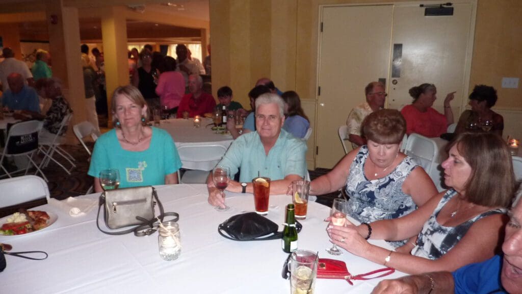Three women sitting at a table in a social gathering.